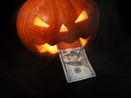 Halloween,Pumpkin,And,Dollars,On,Black,Background.